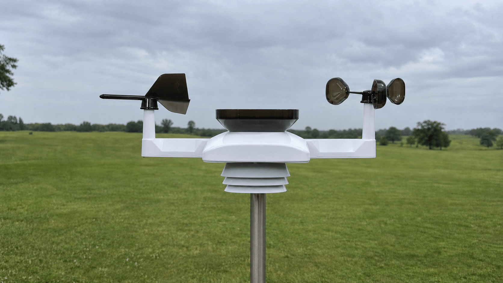 AcuRite Optimus 06050M sensor on one central mast with separate wind vane and three-cup anemometer towers