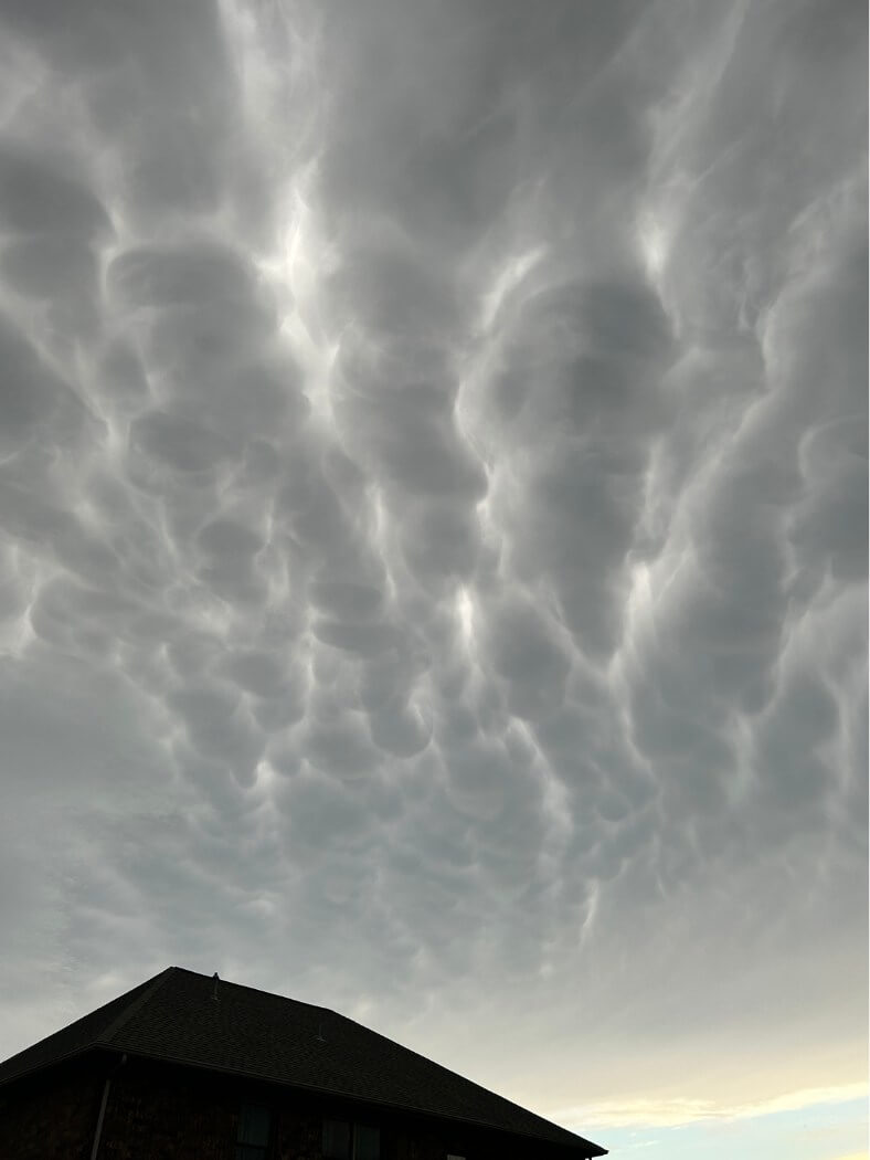 Mammatus clouds above a dark roofline