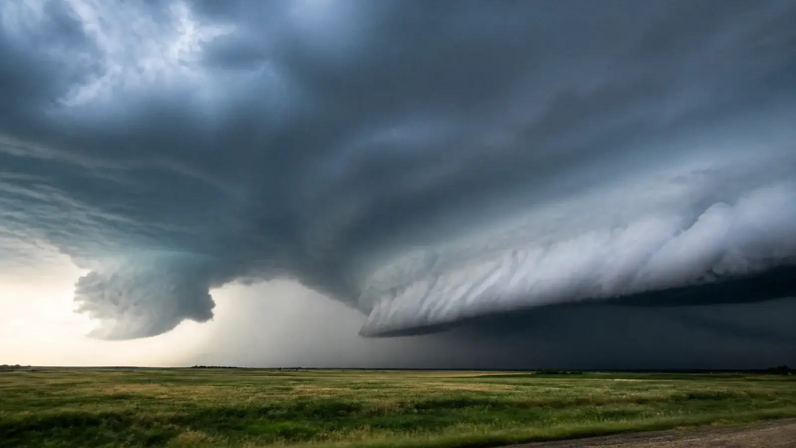 Broad shelf cloud and localized lowering beneath a severe thunderstorm over open land